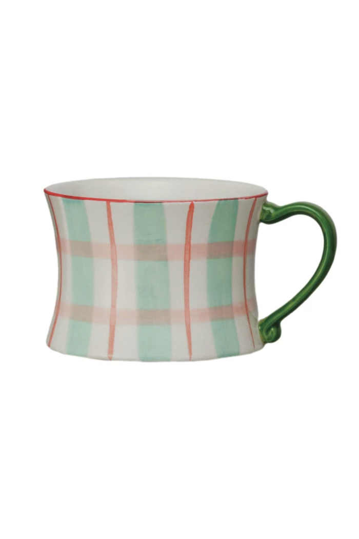 A set of four hand-painted stoneware mugs with various patterns and colored handles.
