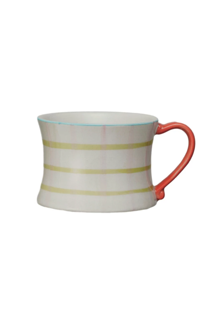 A set of four hand-painted stoneware mugs with various patterns and colored handles.