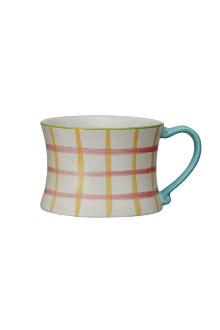 A set of four hand-painted stoneware mugs with various patterns and colored handles.