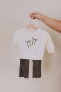 cream sweatshirt with brown bow embroidered design and brown and white striped pants