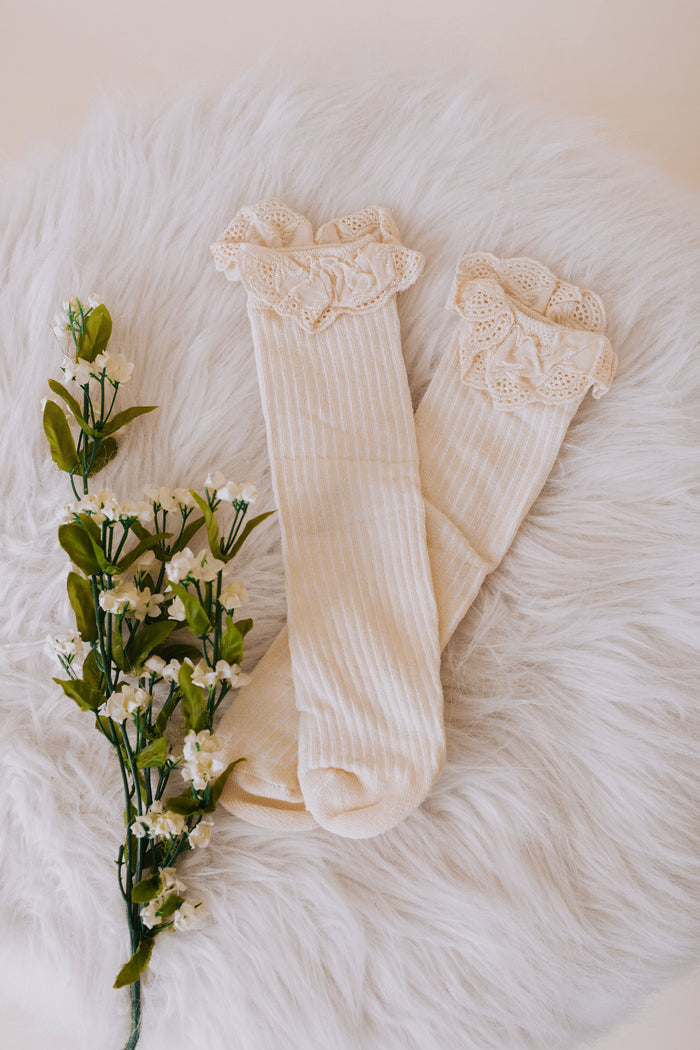 beige baby sock with eyelet lace trim and ribbed material