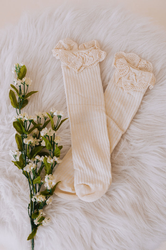 beige baby sock with eyelet lace trim and ribbed material