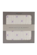 Newcastle blanket with purple flower pattern in packaging on a white background