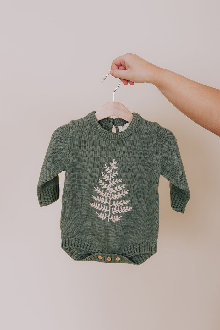 Green baby onesie with long sleeves, crew neck, and white embroidered leaf design and button closure.