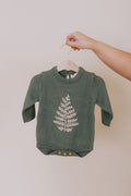 Green baby onesie with long sleeves, crew neck, and white embroidered leaf design and button closure.
