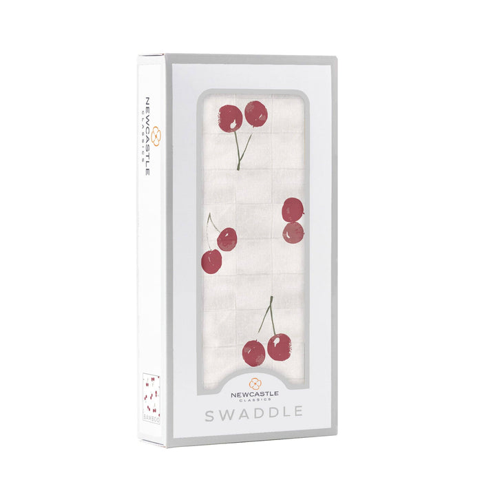 white baby swaddle with cherry pattern by newcastle classics