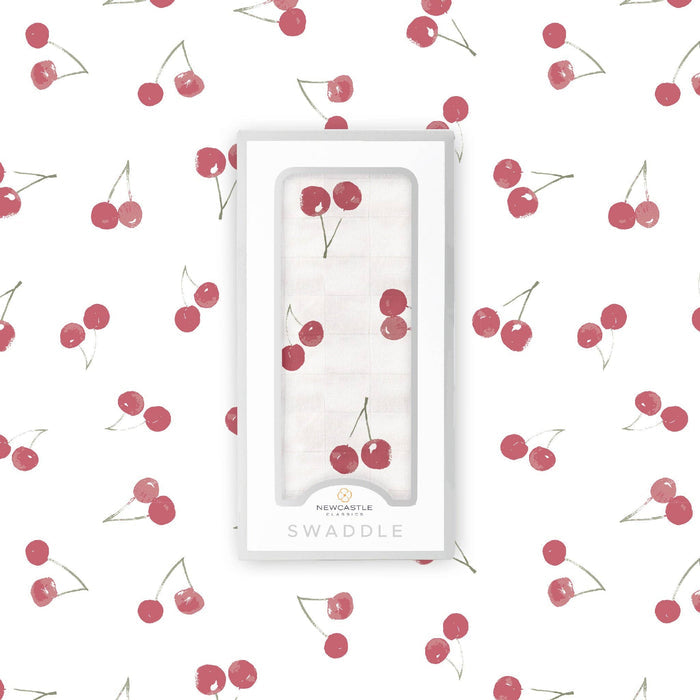 white baby swaddle with cherry pattern by newcastle classics