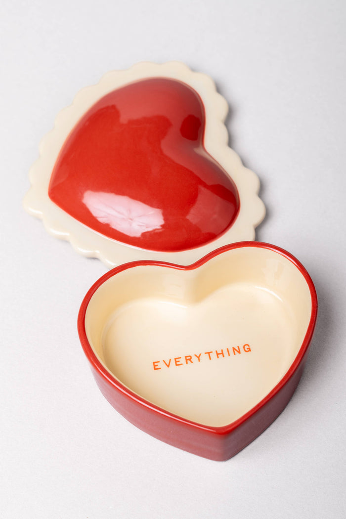 Heart-shaped red and beige container with 'EVERYTHING' text inside on a light gray background