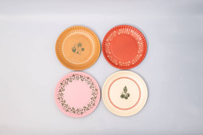 Four decorative plates with floral patterns on a light gray background strawberry tomato