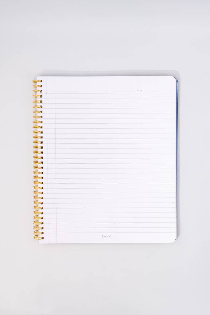 Notebook with gold spiral binding on a white background lined paper
