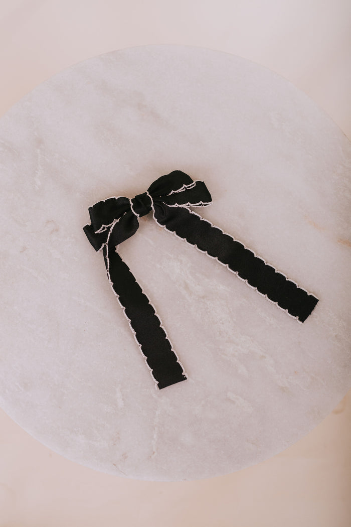 Black bow hair accessory on a white background