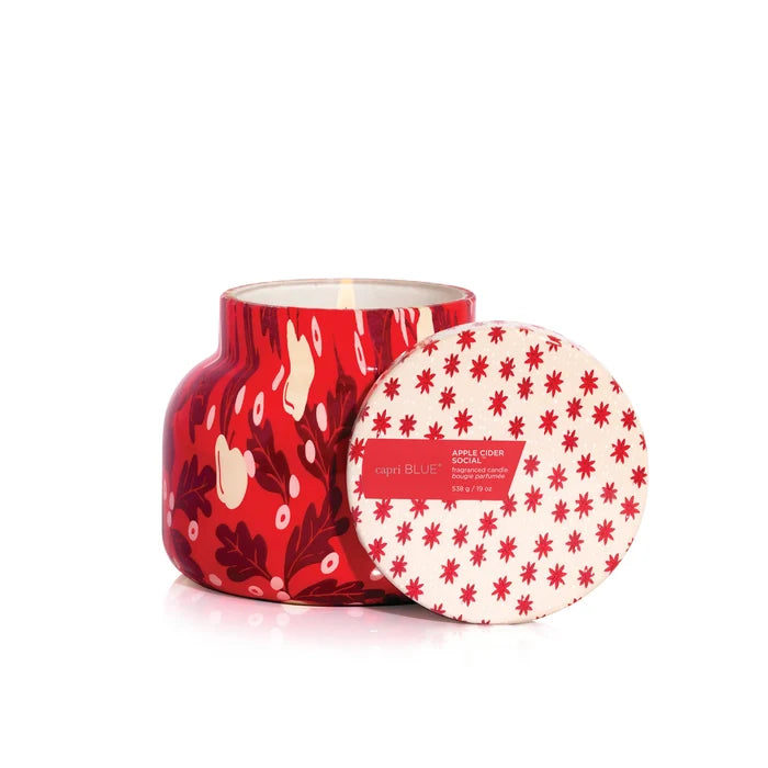 Red and white candle with apple and leaf design and matching lid on a white background