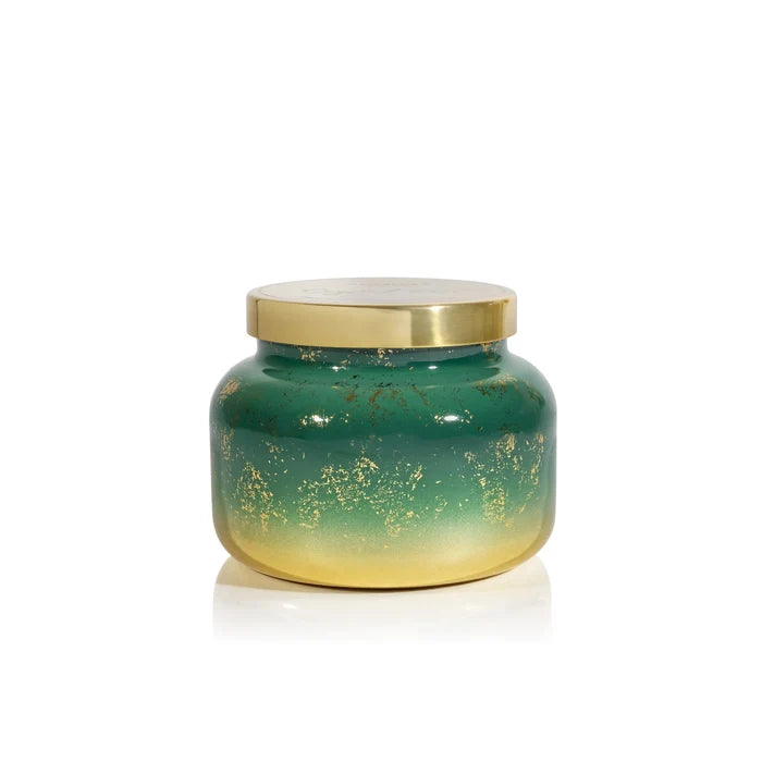 Green candle with gold lid on a white background
