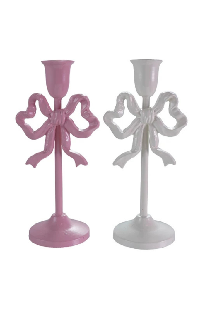Two decorative candle holders with bow designs, one pink and one white, on a white background.