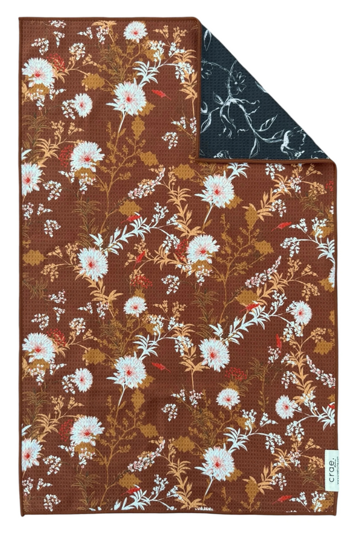Reversible hand towel with floral pattern on brown background.