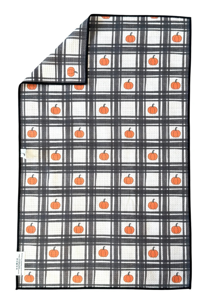 Plaid microfiber hand towel with orange pumpkins on a white background