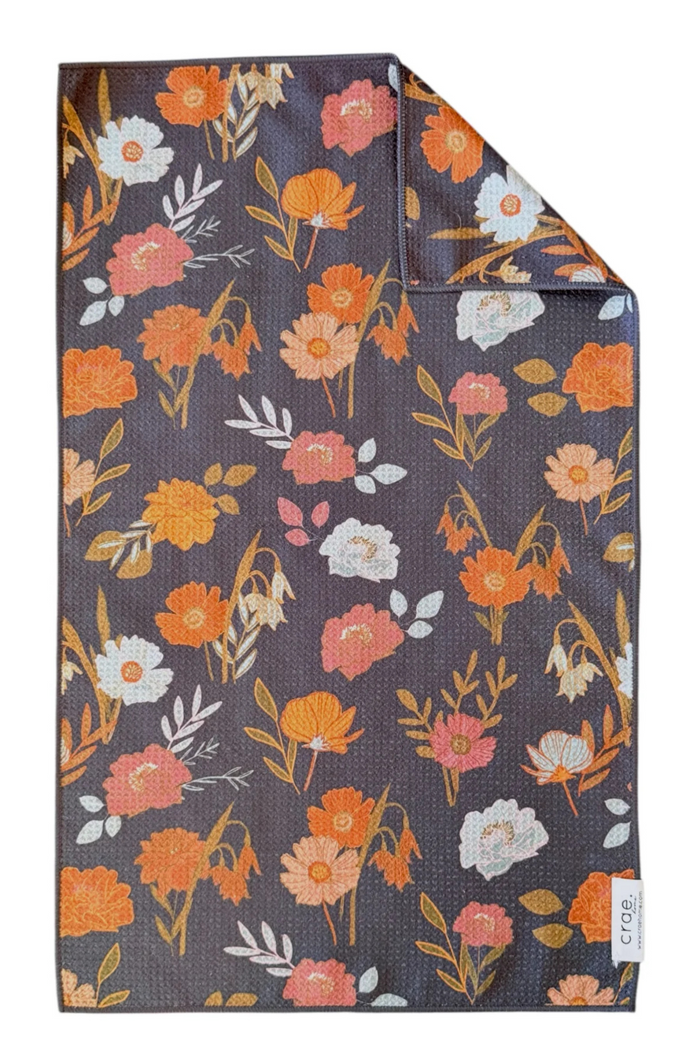 Microfiber hand towel with orange, white, and yellow floral pattern.