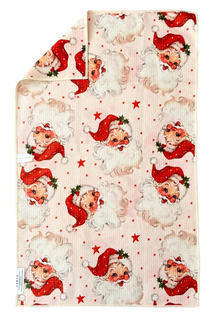 Microfiber hand towel patterned with red stars and Santa Claus faces.