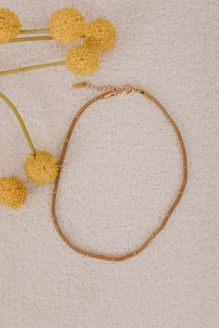 Gold plated stainless steel. Gold mesh chain necklace with a lobster clasp and bead accents.