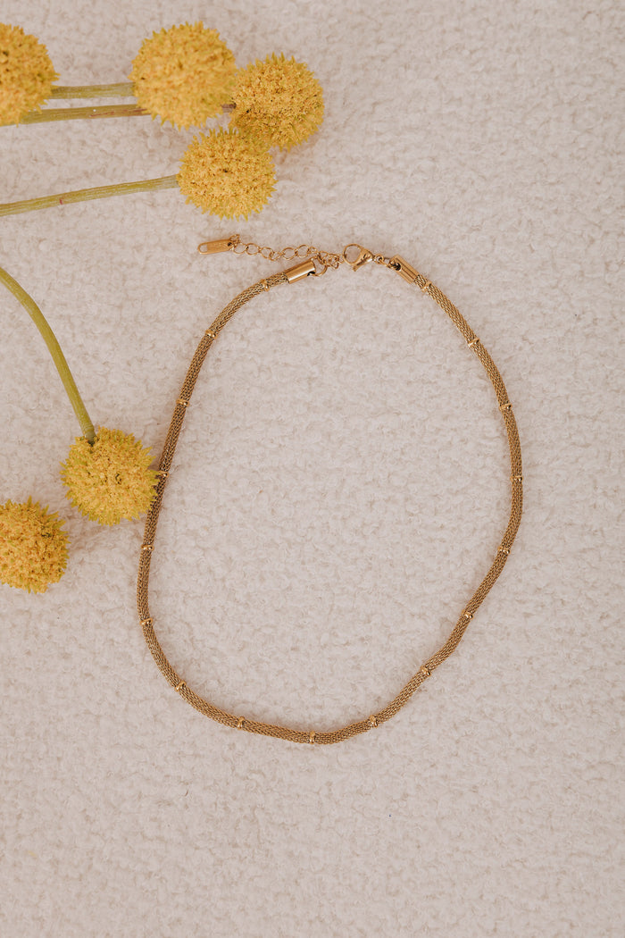 Gold plated stainless steel. Gold mesh chain necklace with a lobster clasp and bead accents.