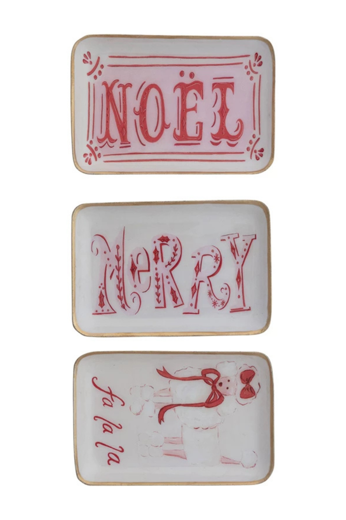 Three decorative trays with 'NOéL', 'MERRY', and 'FA LA LA' in red on a white background.