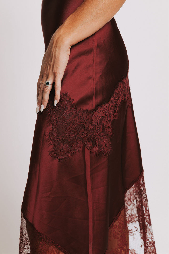 cowl neck dress with lace trimmed asymmetric hemline side close