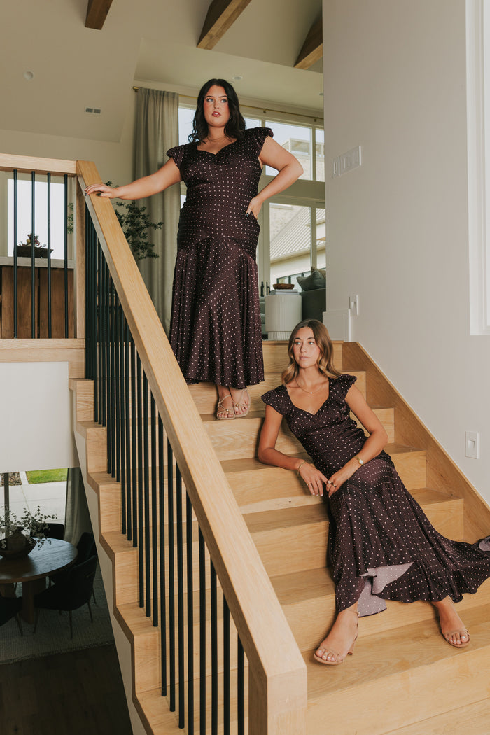 brown satin dress with pink polka dots and cap sleeves models pose lifestyle