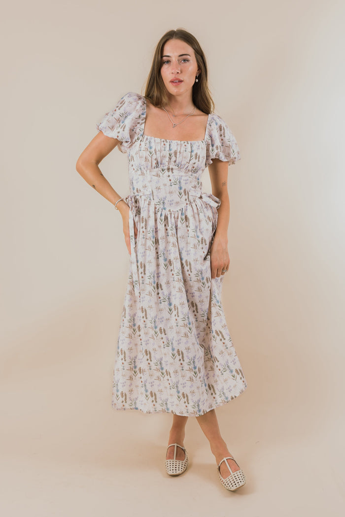 Woman wearing a floral dress against a plain background