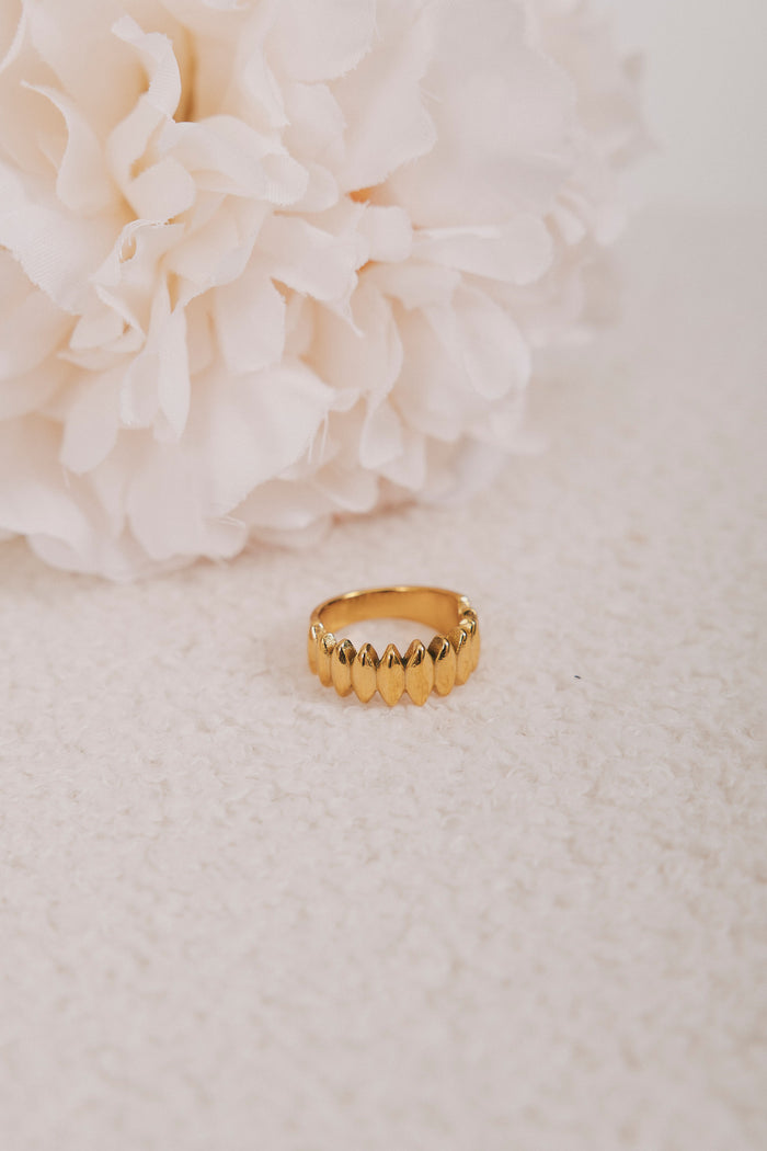 gold ring with diamond design flat lay