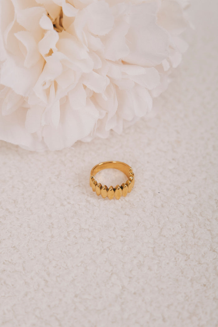gold ring with diamond design flat lay 2