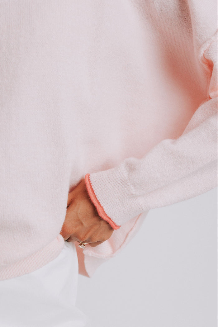 light pink sweater with raw seams and rolled edges close