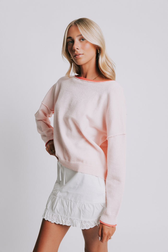 light pink sweater with raw seams and rolled edges side