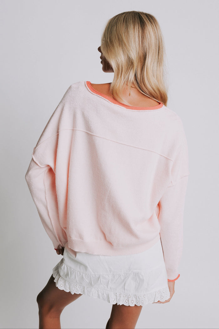 light pink sweater with raw seams and rolled edges back