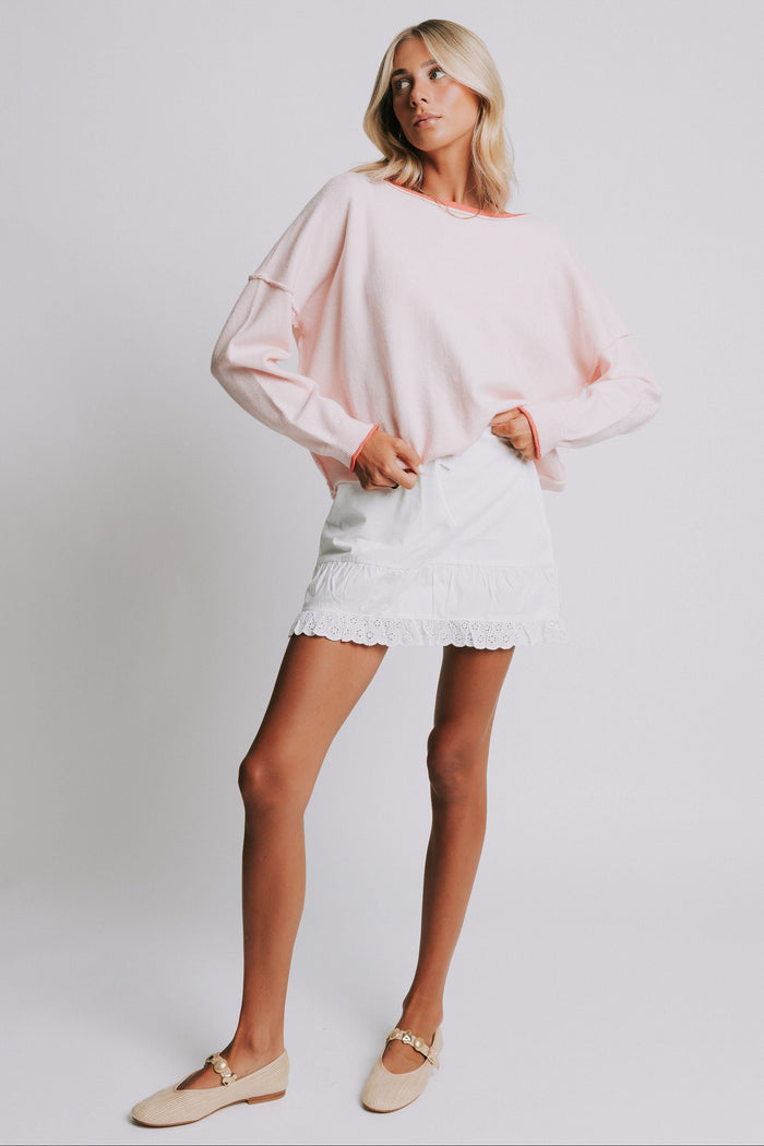 light pink sweater with raw seams and rolled edges full