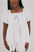 loose white top with blue ribbon detail and lace close