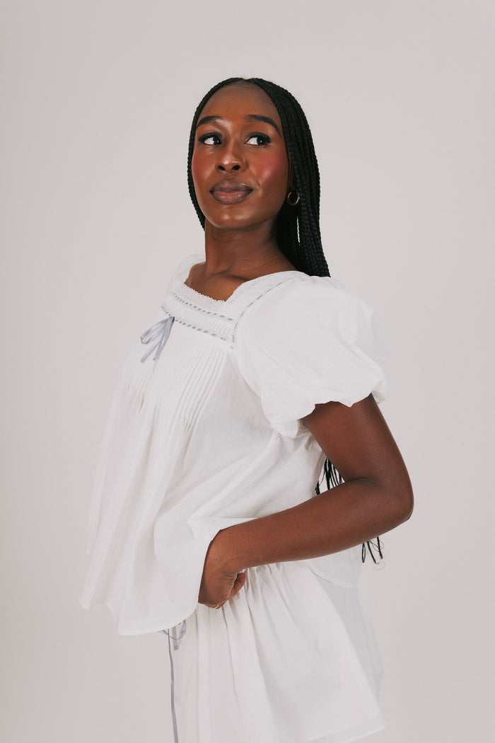loose white top with blue ribbon detail and lace side