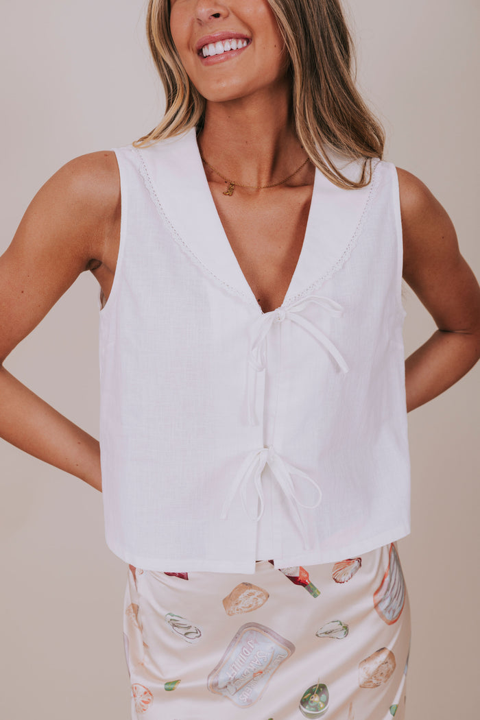 white sleeveless vest with bows detail