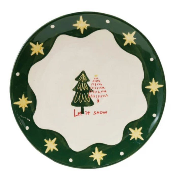 Decorative plate with Christmas tree and 'Let it snow' text on a green border with stars.