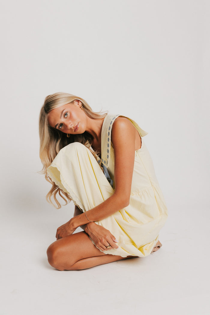 yellow midi dress with pan collar and blue ribbon detail pose