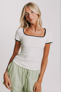 white ribbed top with black trim on neckline and sleeves