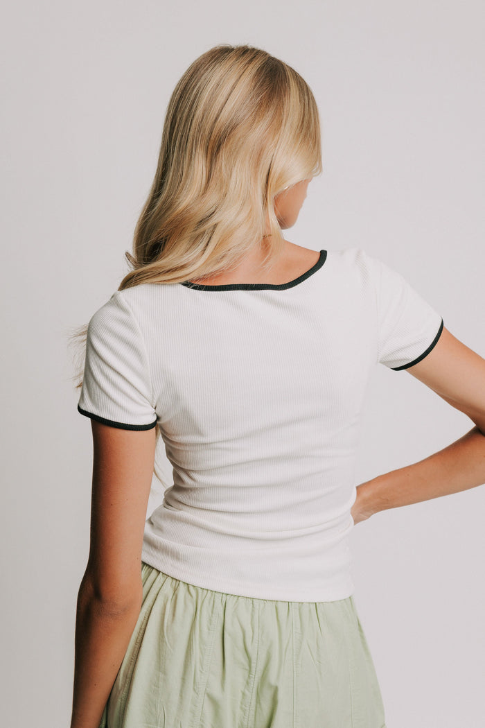 white ribbed top with black trim on neckline and sleeves back