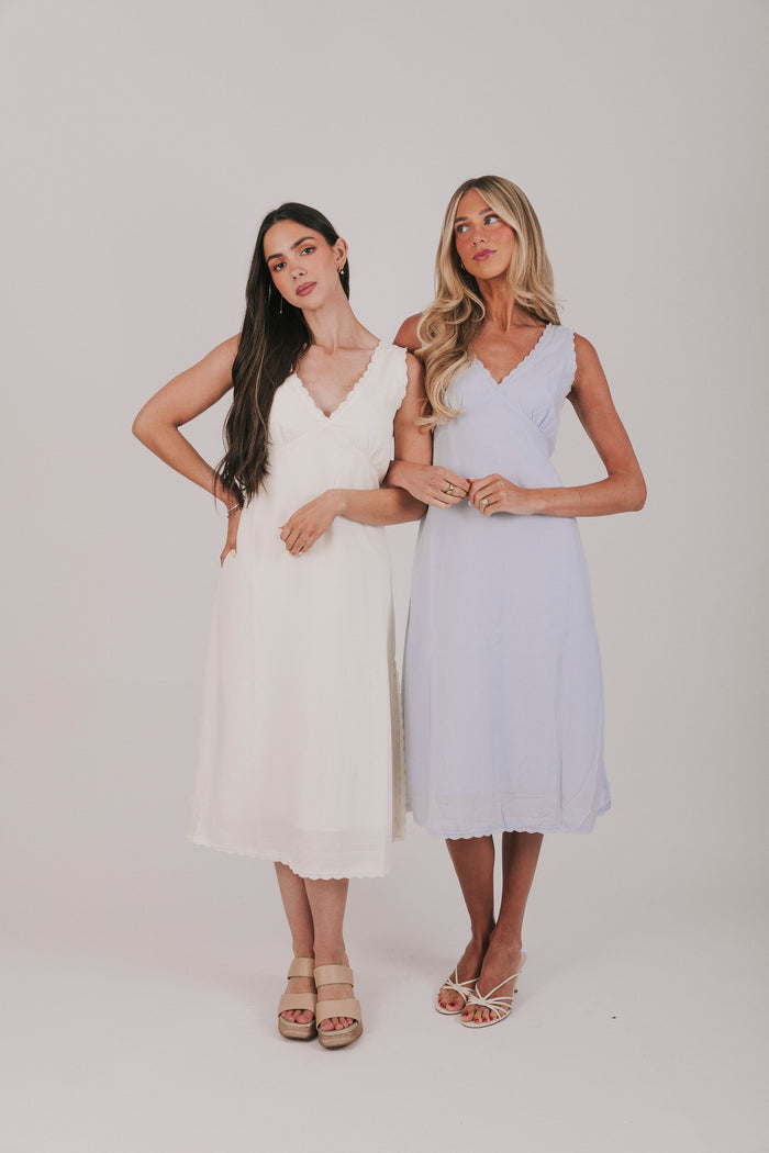 Midi dress that comes in 2 colors, off white and light blue. Sleeveless design with lace trim and side slits.