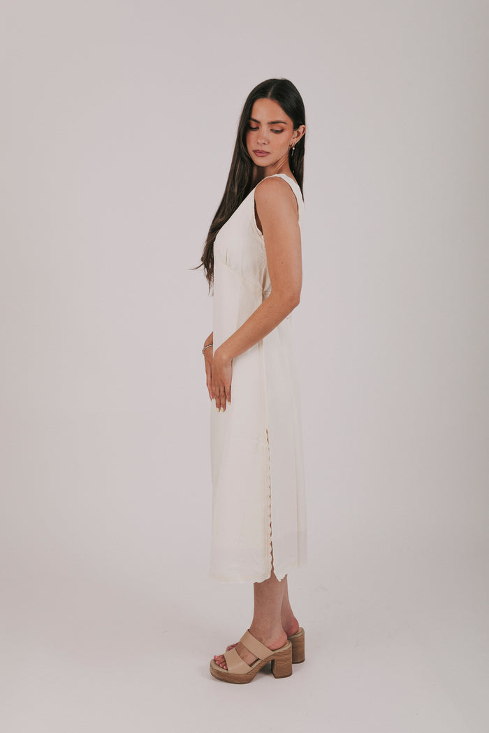Midi dress that comes in 2 colors, off white and light blue. Sleeveless design with lace trim and side slits.