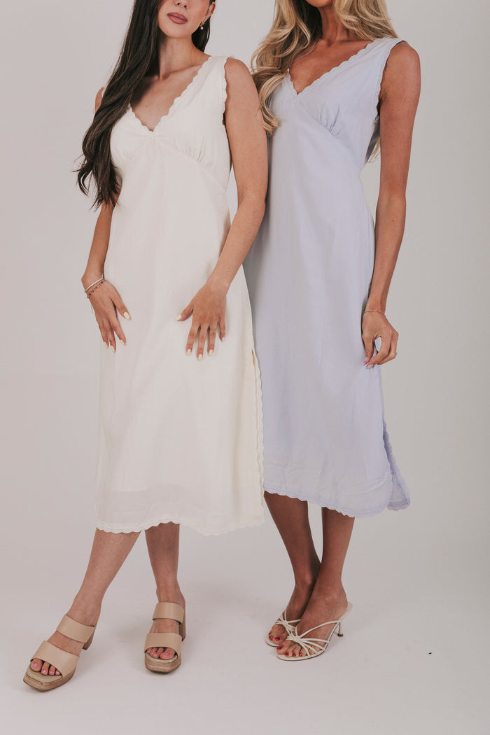 Midi dress that comes in 2 colors, off white and light blue. Sleeveless design with lace trim and side slits.