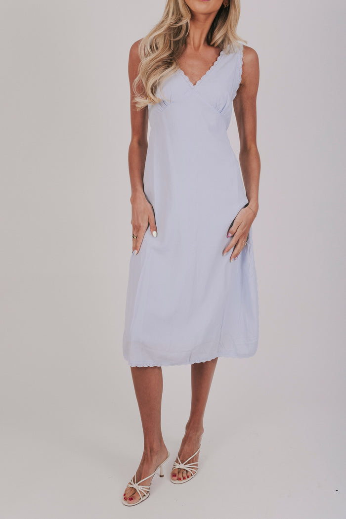 Midi dress that comes in 2 colors, off white and light blue. Sleeveless design with lace trim and side slits.