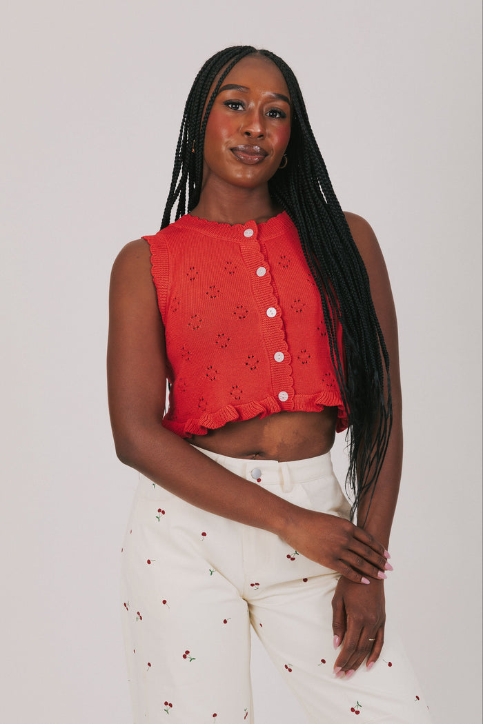 red knitted vest with ruffled hem and buttons