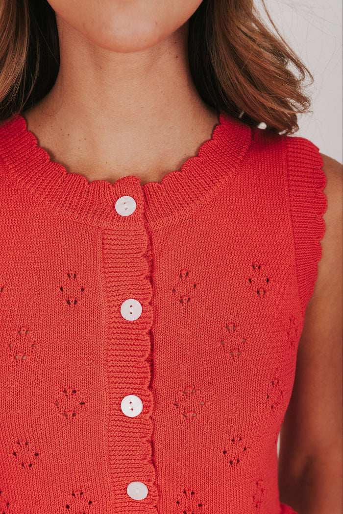 red knitted vest with ruffled hem and buttons