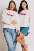 cream sweater with rolled edges and butter emblem models