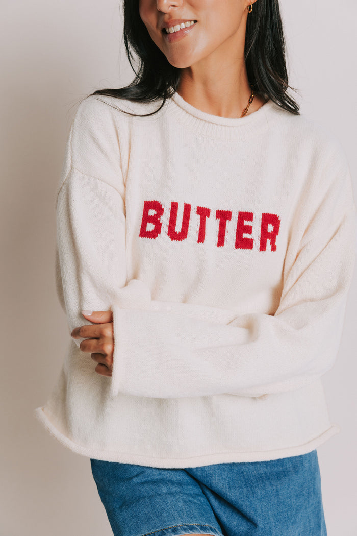 cream sweater with rolled edges and butter emblem front