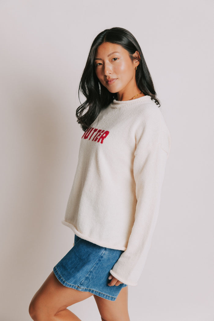 cream sweater with rolled edges and butter emblem side